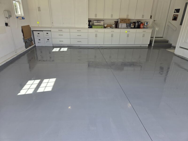 Wide view of the finished epoxy garage floor, with light reflecting off the surface.